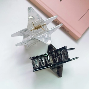 Close-up of star hair claws with marble texture and gold metal springs in top-down view