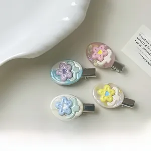 Set of four pastel floral acetate duckbill hair clips on an elegant white ceramic plate