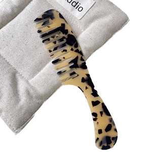 Classic tortoise shell acetate wide-tooth hair comb with marble pattern on soft pouch
