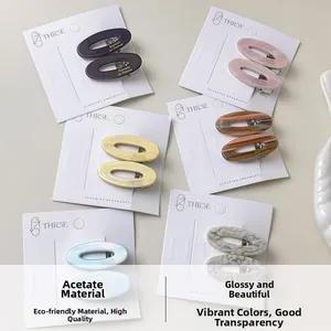Close-up of assorted oval acetate hair clips in multiple colors on branded display cards
