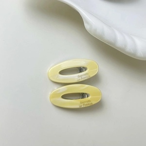 Detail view of oval marble pattern hair clips with Barrette la France logo engraving