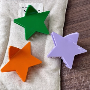 Three colorful star hair claws in vibrant green, purple and orange for women's hairstyling