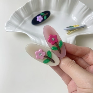 Elegant oval acetate hair clips with rhinestone floral details in assorted pastel colors