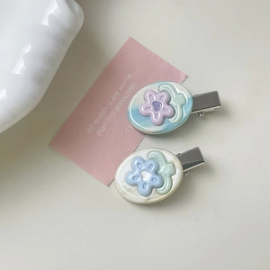 Detail shot of pastel floral resin hair clips with silver metal duckbill attachment