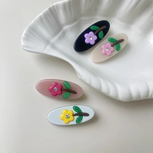 Floral acetate hair clips with rhinestones in navy, cream, pink, and white colors