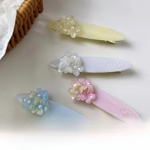 Détail de barrettes à cheveux en acétate avec motif floral et perles élégantes