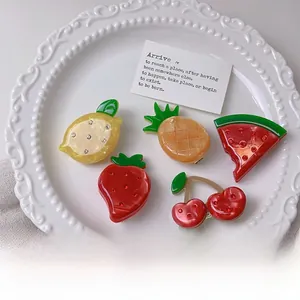 Detail of fruit acetate hair clips featuring lemon and strawberry with tiny rhinestones