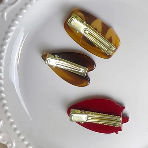 Lot de trois jolies barrettes avec fraise et motifs de cœur sur une assiette décor