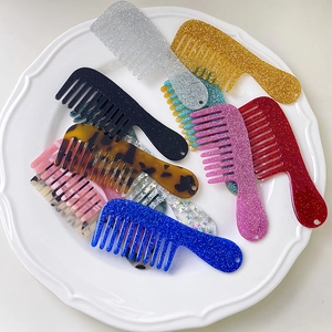 Macro detail of glittery mini hair combs in various colors displayed on a white tray