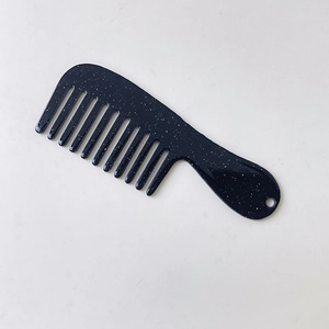 Detail of mini wide-tooth comb with white starry texture and hanging hole for portability