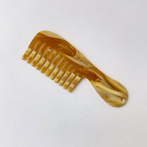 Detail of tortoise shell acetate wide-tooth mini comb with marble pattern and hang hole