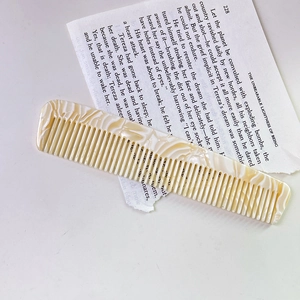 Detailed macro view of an acetate hair comb with elegant marble texture on vintage paper