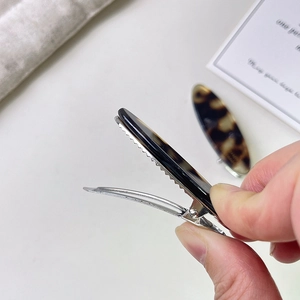 Close-up of acetate alligator hair clip showing anti-slip teeth and metal spring mechanism