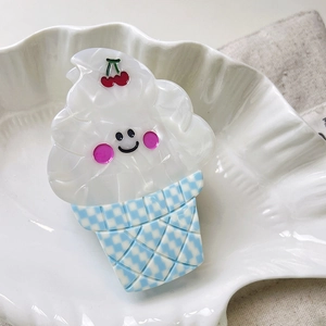 Detailed shot of ice cream hair claw with red cherry on a wavy ceramic plate