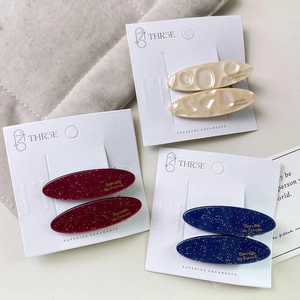 Three pairs of elegant oval acetate hair clips in cream white, burgundy red and navy blue