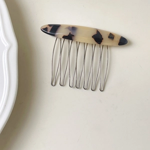 Detail view of handmade tortoiseshell acetate hair comb with eight silver metal teeth