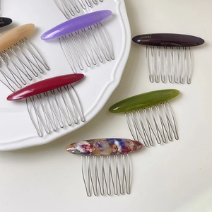 Elegant oval acetate hair combs with gold lettering and metal teeth in multiple colors