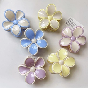 Chic floral hair claws in pastel blue, purple, and yellow for elegant hair styling