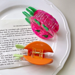 Vista dettagliata delle mollette creative a forma di dragon fruit e carota su piatto