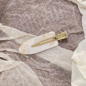 Close-up of marble pattern acetate hair clip with golden metal crocodile grip