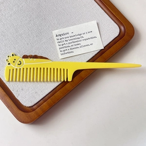 Détail d'un peigne girafe jaune vif avec une queue pointue et des dents de lissage