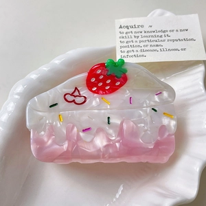 Vue de dessus d'une pince à cheveux gâteau à la crème en acétate rose et fraise