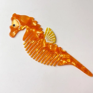 Gros plan détaillé d'un peigne en forme d'hippocampe orange avec texture marbrée