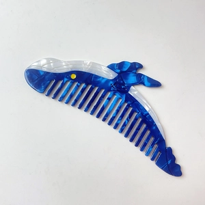 Détail du peigne en acétate en forme de baleine avec des textures de marbre bleu et blanc