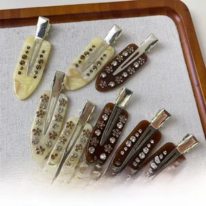 Close-up of acetic acid hair clips with rhinestones in marble and brown textures
