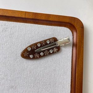Detail of vintage brown acetate hair clip with floral rhinestones on silver duckbill clip