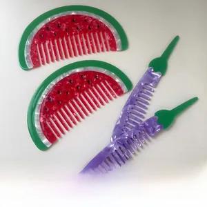 Detail of creative acetate hair combs in realistic watermelon and eggplant shapes