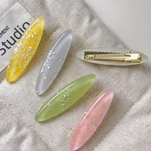 Elegant oval shell-style hair clips set in translucent colors with gold duckbill grip
