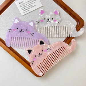 Dettaglio ravvicinato di pettini per capelli in acetato a forma di gatto, rosa e viola