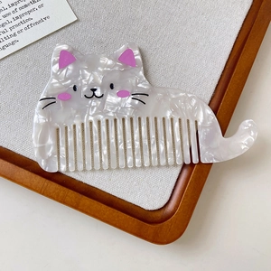 Vue détaillée macro du peigne chat en acétate marbré blanc avec finition nacrée scintillante