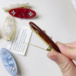 Detail of vintage butterfly hair clip with rhinestones and gold alligator clip base
