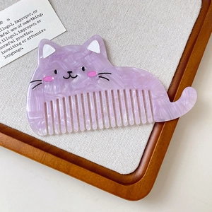 Détail d'un peigne à cheveux violet marbré en forme de chat avec des dents fines et mignon