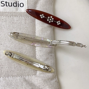 Macro detail of tortoiseshell duckbill hair clips with sparkling crystal flower accents