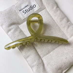 Olive green jelly square hair claw clip with gold spring on a beige canvas pouch