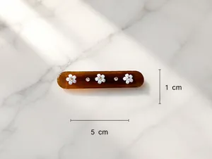 Detailed close-up of a 5cm floral rhinestone hair clip in brown resin with dimensions
