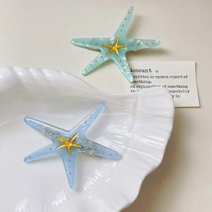 Y2K style acetate starfish hair clips in blue and green colors with gold accents