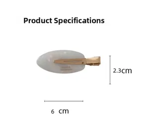 Vue détaillée de la pince à cheveux ovale en acétate avec base dorée 6cm x 2,3cm
