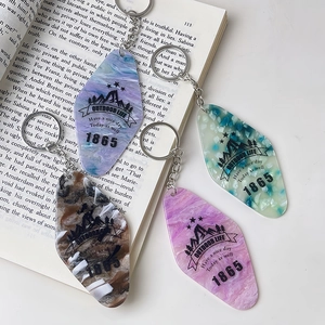 Flat lay of colorful acrylic motel style keychains on a book with marble textures