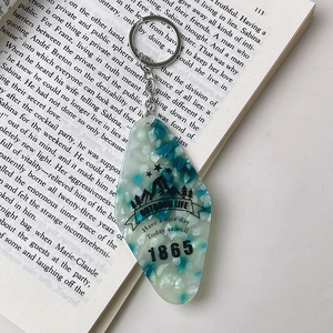 Detail view of a vintage rhombus acrylic keychain with outdoor life patterns on a book