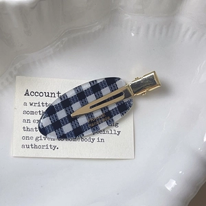 Barrette à cheveux à damier faite main avec fermoir doré sur une assiette déco