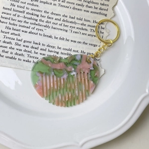 Mini heart-shaped acetate comb keychain with marble texture on vintage paper background