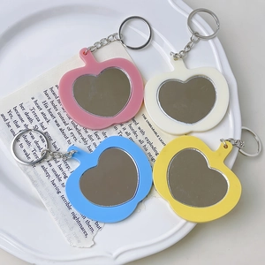Set de cuatro llaveros espejo con forma de manzana en rosa, azul, blanco y amarillo