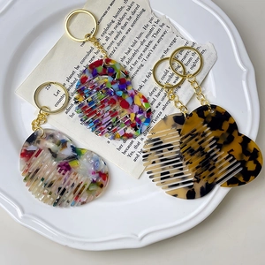 Mini heart-shaped acetate hair comb keychain with premium textures and gold keyring