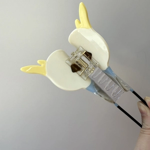 Detail of cockatiel bird hair claw clip showing resin texture and metal spring mechanism