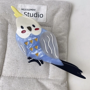 Detail view of cartoon parrot hair claw clip made of colorful acetate material