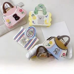 Close-up of cute handbag-shaped acetate hair claws with bear and floral patterns